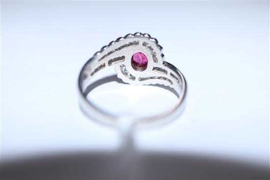 A modern stylish 18ct white gold, ruby and diamond oval cluster ring, with diamond set shoulders, size L/M.